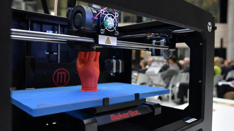 **Testo alternativo (alt text) in italiano:**
Stampante 3D MakerBot stampa prototipo rosso con progettazione fluida e rapida.