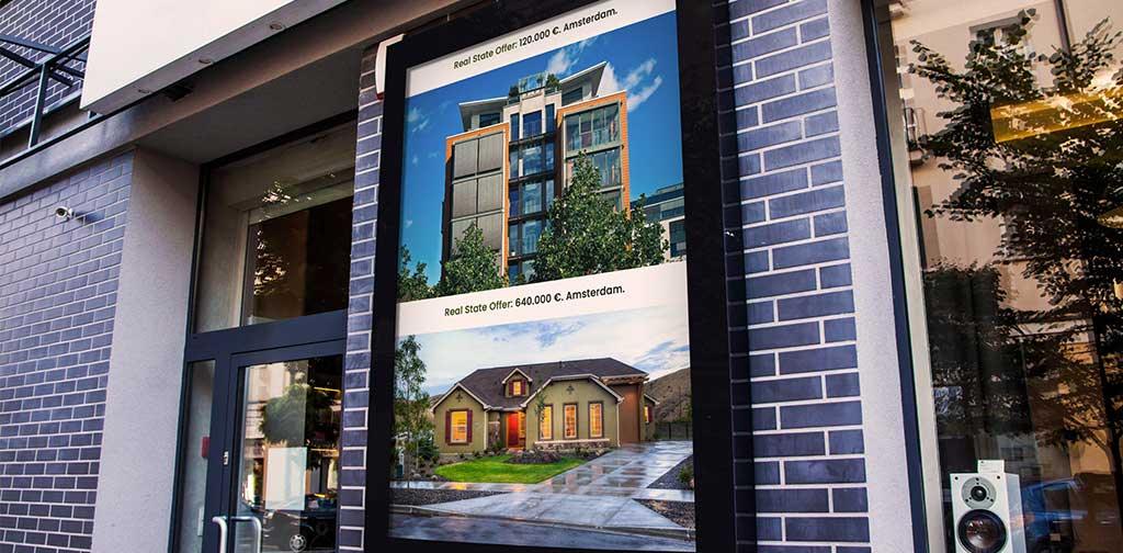 Testo alternativo (alt text) in italiano:Digital signage per immobili: schermo LED promuove case ad Amsterdam