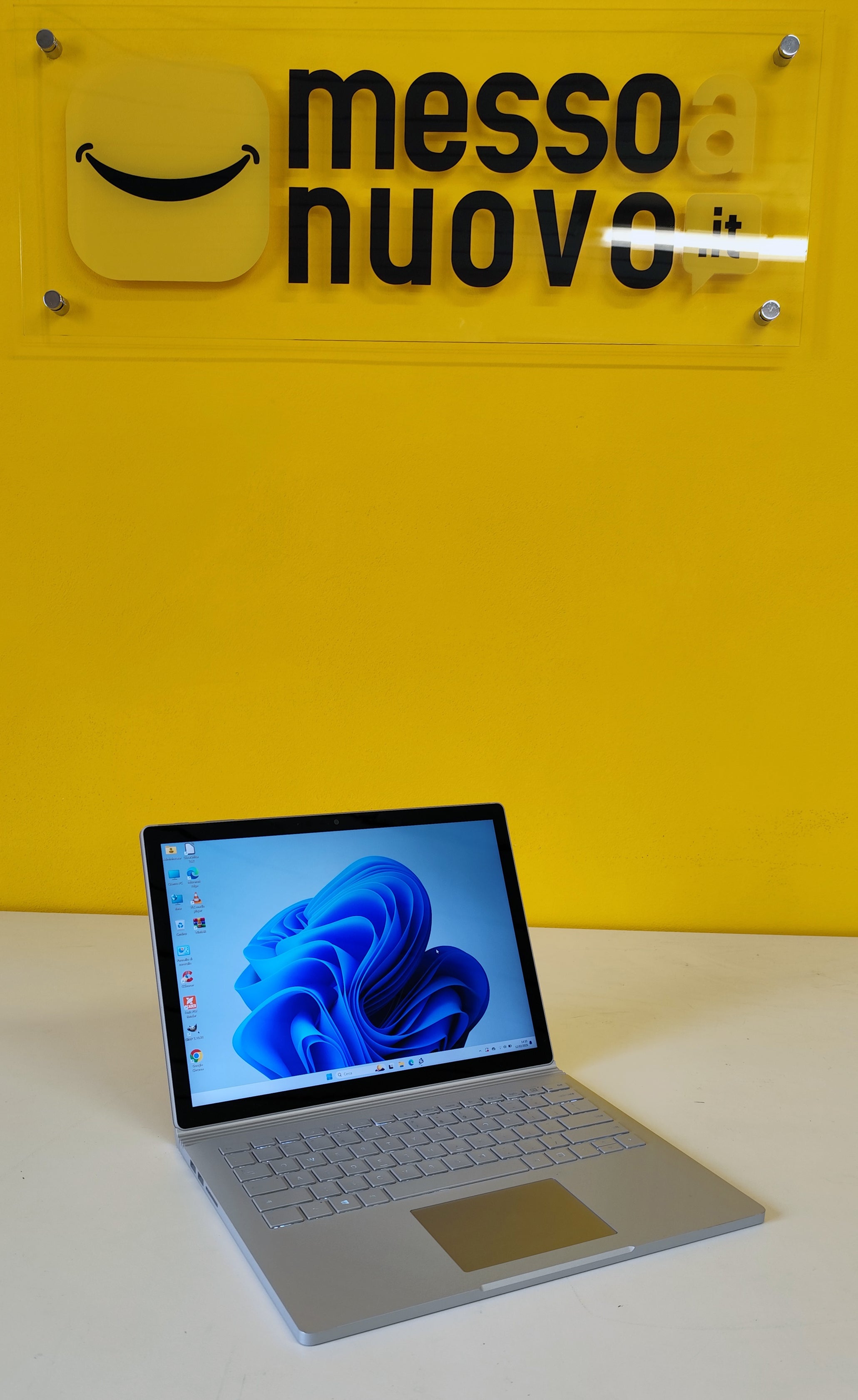 Microsoft Surface Book 3 ricondizionato acceso con Windows 11, esposto su banco bianco presso rivenditore Messoanuovo.